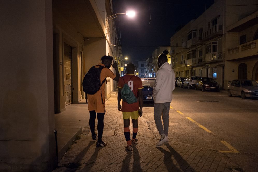 The trio walking down a street in Fgura after their football match.