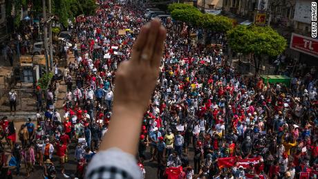  A protester makes a three-finger salute as others march on February 7 in Yangon, Myanmar. 