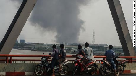 Smoke rises as protests against military coup and detention of elected government members continue in Hlaingtharya Township, Yangon, on March 14.