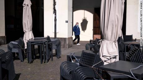 A man walks near a closed bar in Piazza Vittorio in Turin on March 17, 2021.