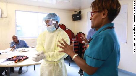 Janlyn Kumbu of PNG&#39;s Central Public Health Laboratory trains health workers in Vanimo, West Sepik, on proper PPE procedures.