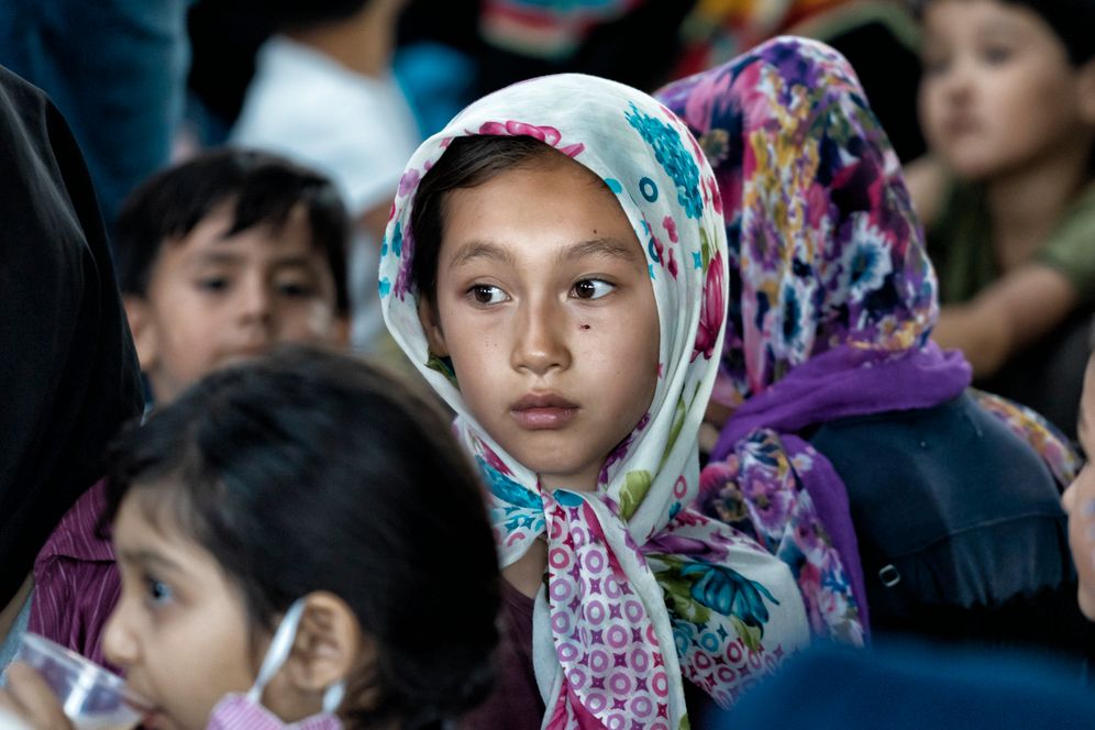 Camp Moria: Children standing in line waiting for drinks.