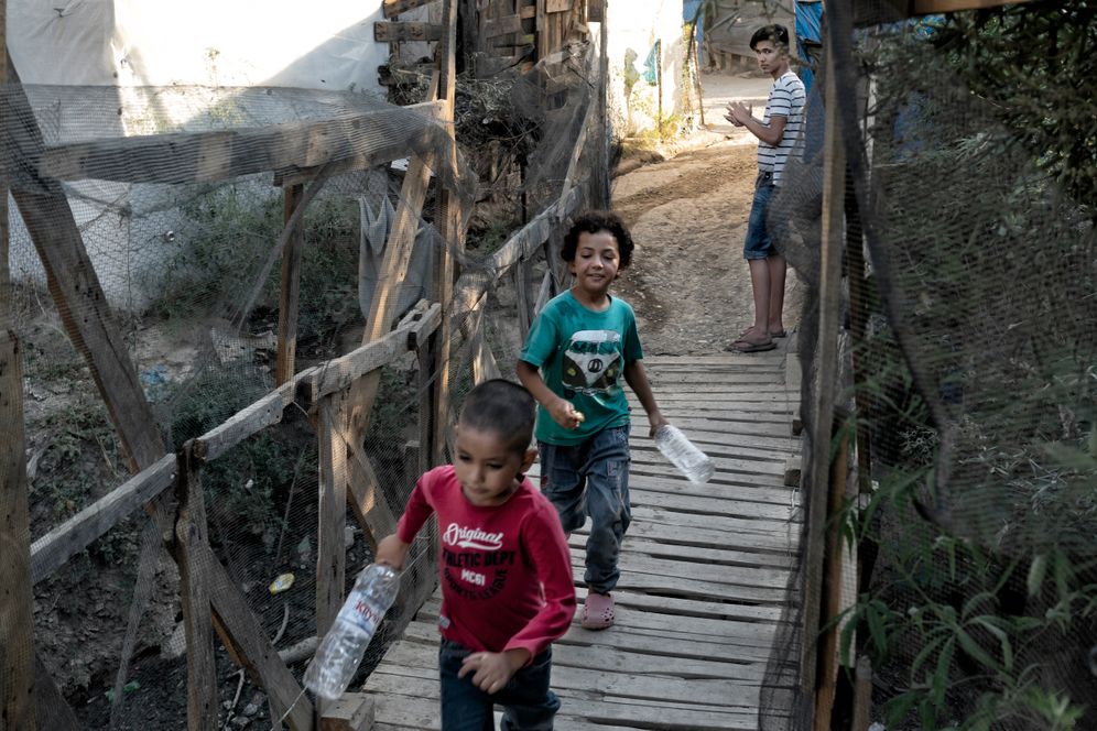 Children in Moria playing with water bottles. Mohammad is standing to the right.