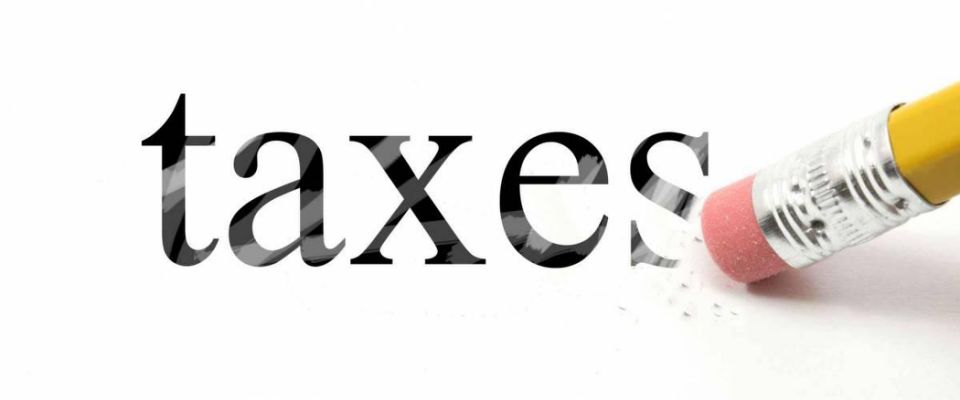 An eraser from a pencil is starting to erase the word Taxes making a great concept.