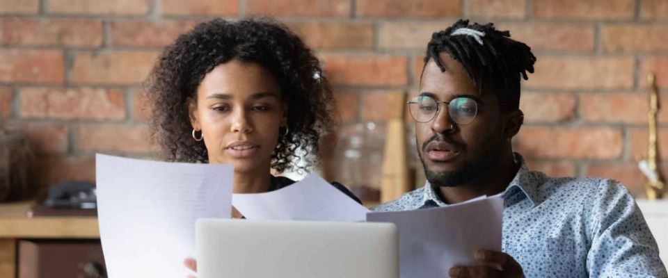 Focused African American young couple reviewing their student loan debt.