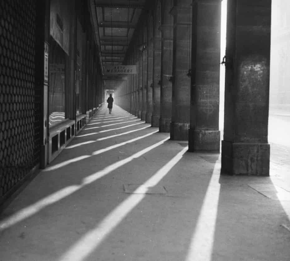 Parisian arcade, circa 1950: A woman walks beside the large pillars of the arcade at the western end of the Rue Rivoli, Paris.