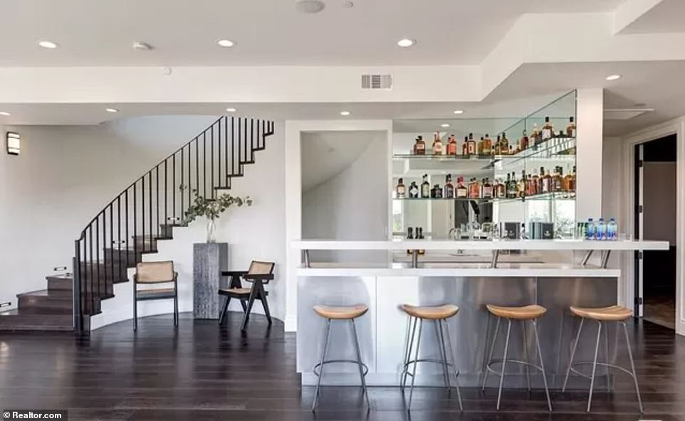 Cheers! A spiral staircase leads to a home bar