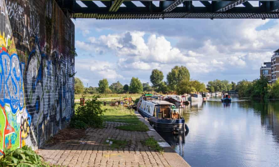 UK, London. Urban landscape - houseboats on the River Lea navigable canal section with graffiti under a railway bridge and a clear summer sky2D35G0T UK, London. Urban landscape - houseboats on the River Lea navigable canal section with graffiti under a railway bridge and a clear summer sky