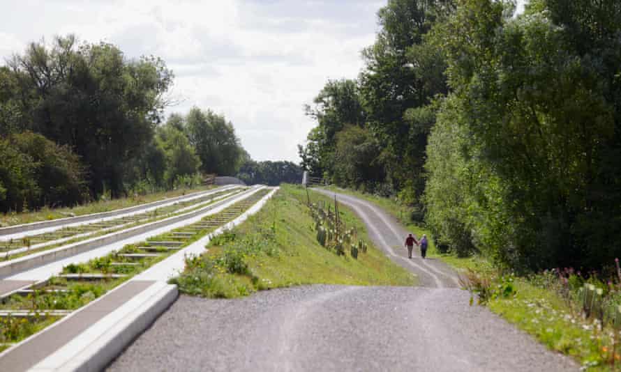 Couple walking beside Cambridge Guided Busway at St Ives.