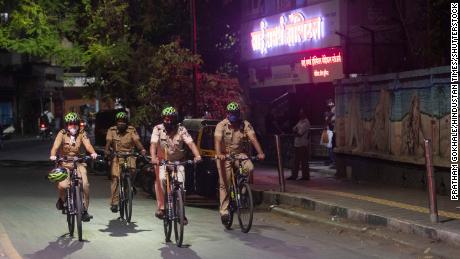 Police personnel patrol Pune, India, on April 3, as new evening curfews go into effect. 