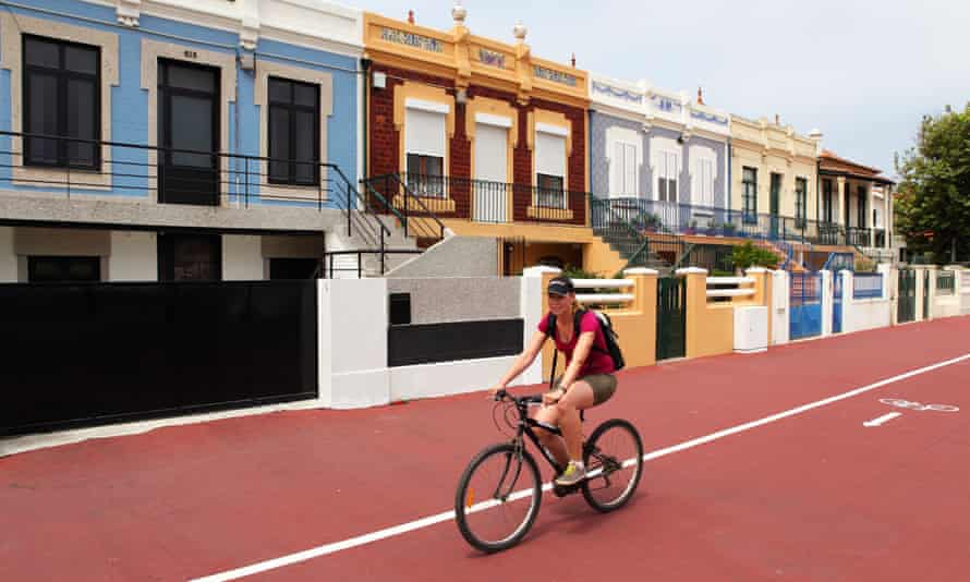 A woman cycles on a cycle-path at Espinho in Portugal.