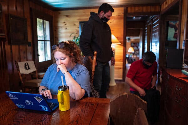 Rylee Hinds, a high school senior, does coursework while a crew installs broadband internet in her family’s home in Mantachie, Miss., in February.