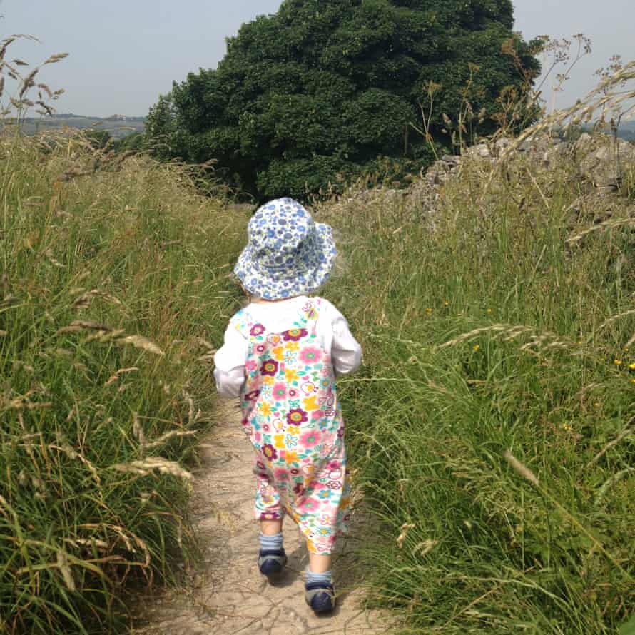 Child walking in grassland on the Monsal Trail, Derbyshire, UK.