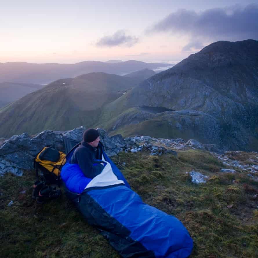 Hiker bivouac at the summit of Knocknahillion mountain, Maumturk Mountains, Connemara, County Galway, Ireland.