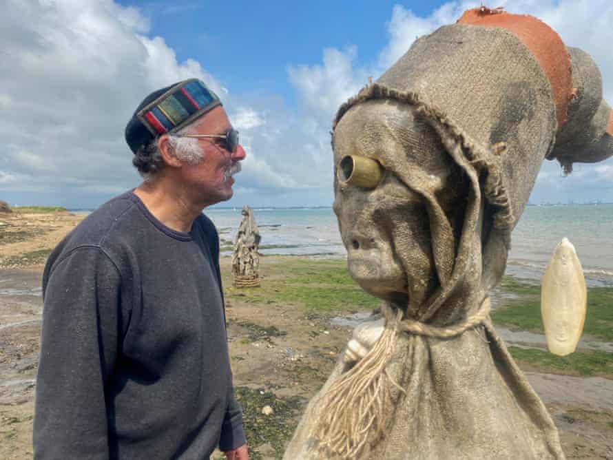 Artist Nabil Ali with a figure from his Essex beach installation, The Sea People