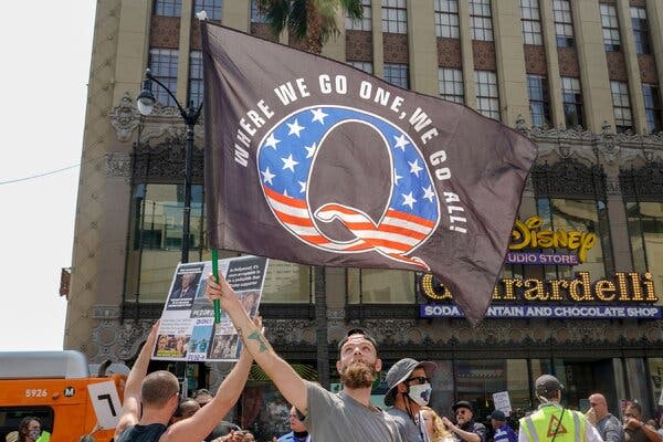 A QAnon flag at a demonstration in Los Angeles in August. Last year, views of videos on pro-QAnon channels rose 38 percent, a new report says.