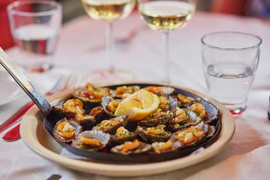 Grilled limpets served with lemon - traditional seafood on Madeira island, Portugal. Selective focus.