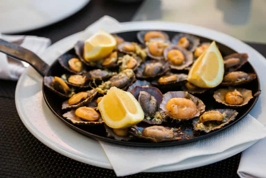 Grilled limpets served with lemon.