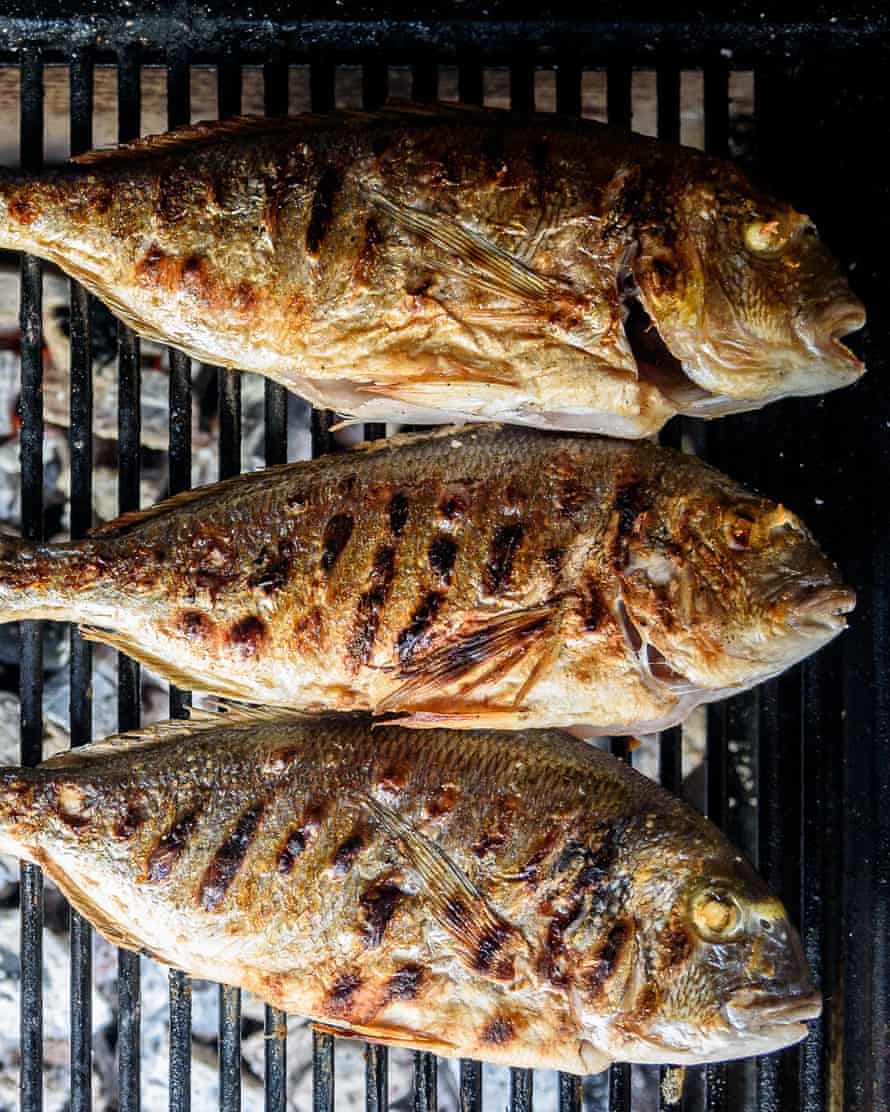 Preparing fish on the charcoal grill.