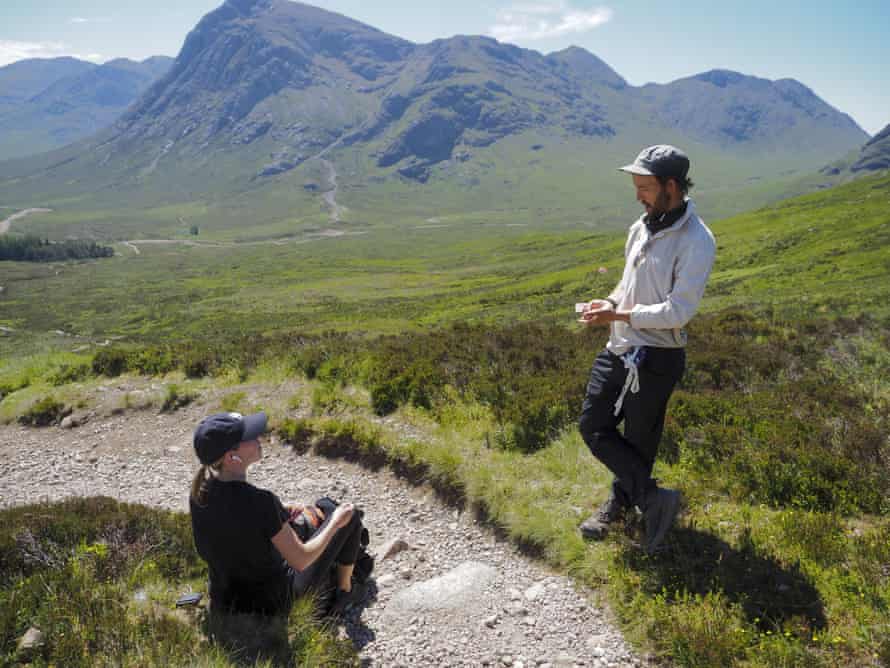 Man and woman on path by mountains