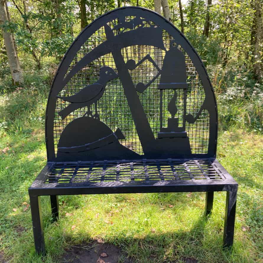 A bench along the path featuring symbols of the area’s mining history, Merseyside, UK