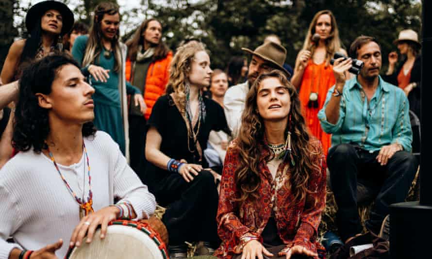 Guests at the Medicine festival near Berkshire, UK, take part in a storytelling and song session around a fire circle, during the daytime.