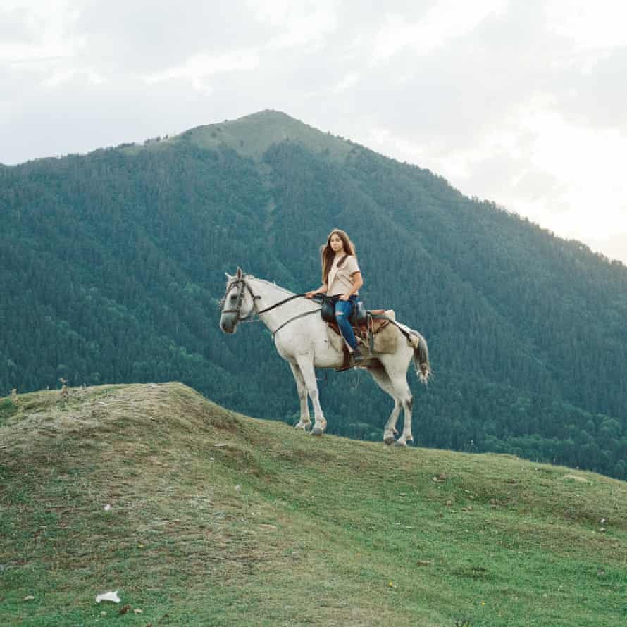 Maria Gochitashvili, on a holiday, taking turns with her parents riding a horse in Upper Omalo